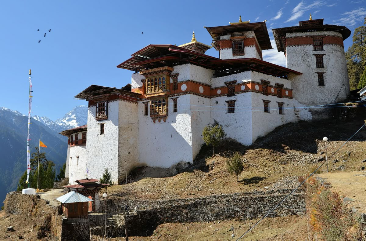 Gasa Dzong perched above the mountains with prayer flags