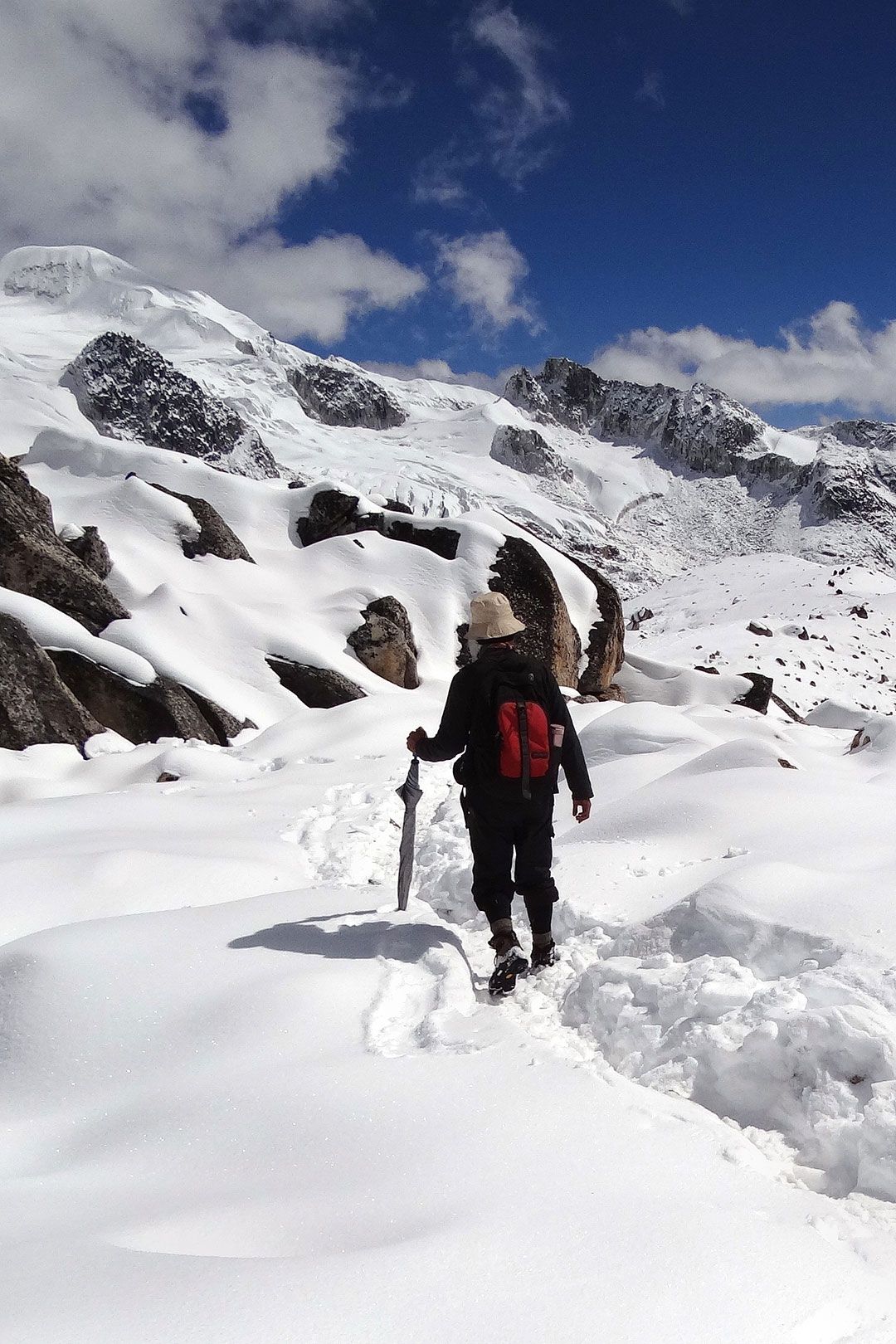 Trekker walking through deep snow on the Snowman Trek route