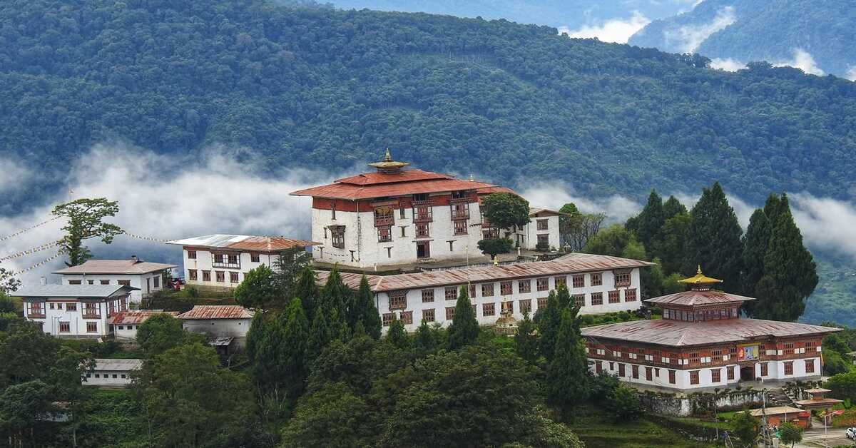 Zhemgang Dzong rising above misty forested hills